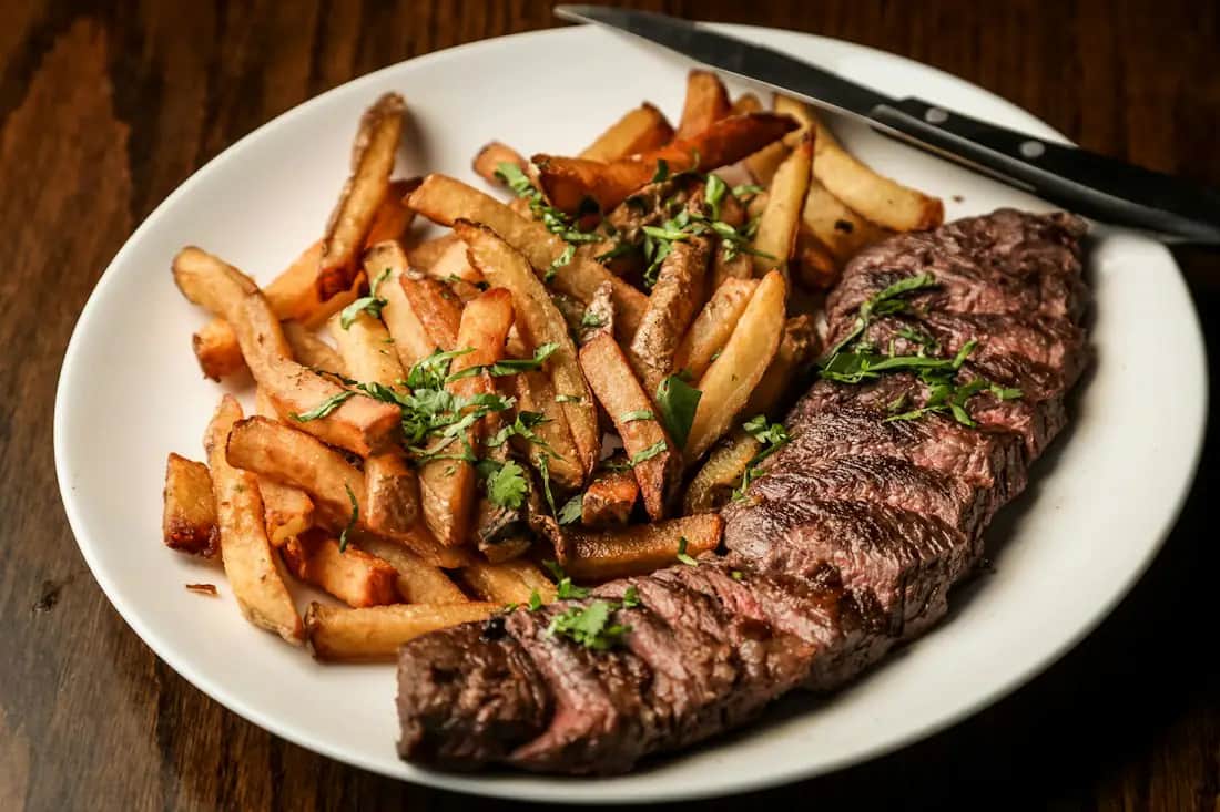 Hands carving a steak tableside